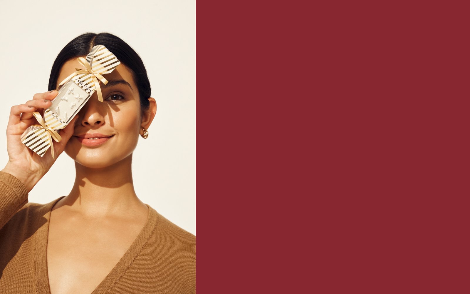 Anne Klein model holding earring jewelry set box over half of her face